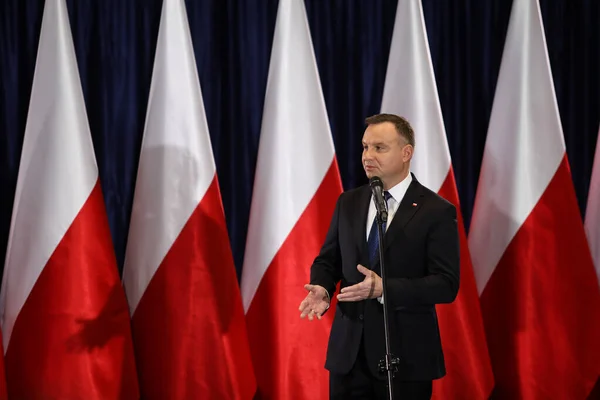 Wloszczowa, Polonya - 06 Şubat 2020: Polonya Cumhurbaşkanı Andrzej Duda 'nın portresi, seçmenlerle yaptığı toplantıda beyaz ve kırmızı bayrakların arka planında