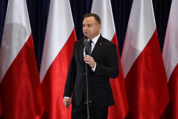Wloszczowa, Polonya - 06 Şubat 2020: Polonya Cumhurbaşkanı Andrzej Duda 'nın portresi, seçmenlerle yaptığı toplantıda beyaz ve kırmızı bayrakların arka planında
