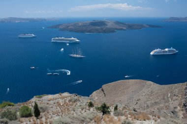 Santorini, Yunanistan: kayaların arka planında su üzerinde tekne