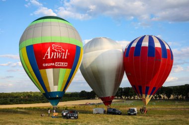 POLAND, JANOW - 18 Temmuz 2019: Üçüncü Jurassic sıcak hava balonu yarışması, Krakow-Czestochowa Upland. Mavi gökyüzünde renkli balonlar