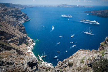 Santorini, Yunanistan: kayaların arka planında su üzerinde tekne