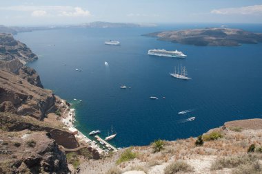 Santorini, Yunanistan: kayaların arka planında su üzerinde tekne