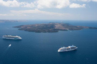 Santorini, Yunanistan: kayaların arka planında su üzerinde tekne