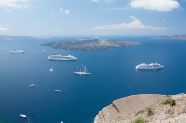 Santorini, Yunanistan: kayaların arka planında su üzerinde tekne