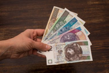 Çeşitli banknotları kapat. Polonya parası, zloti, PLN eski ahşap bir arka planda vantilatör şeklinde tutuluyor.