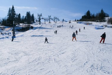 POLAND, ZAKOPANE, WitoW SKI RESORT- 14 Şubat 2020: Kayakçılar ve snowboardcularla dolu karlı kayak yamacı