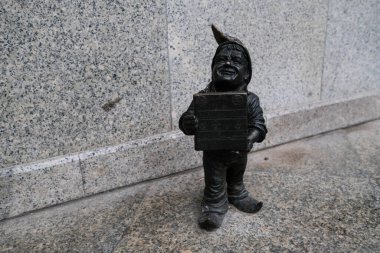 Wroclaw, Polonya - 19 Ocak 2020: Wroclawiak isimli cüce heykelcik kitabı elinde tutuyor- Wroclaw / Ich çöplüğünde, Wreslau geboren- Wroclaw Archdiocesan Kitapevi yakınlarında doğdum.