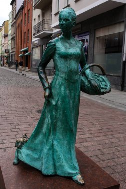 Torun, Polonya - 12 Aralık 2020: Torun 'daki zencefilli kek anıtı. Elinde bir sepet dolusu zencefilli çörek tutan zencefilli kurabiye, patinli bronz.