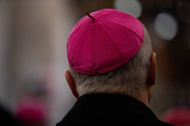 Czestochowa, Poland, Jasna Gora Monastery - 18 November 2019: clerics in the amaranth zucchetto (form-fitting ecclesiastical skullcap) praying during the mass in the chapel clipart