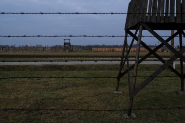 Auschwitz, Oswiecim, Polonya - 27 Ocak 2020: Auschwitz Toplama Kampı Yahudi Soykırımı Müzesi 'nin bir bölümü, dikenli telli elektrikli çit ve izleme kulesi, Arbeit Macht Frei