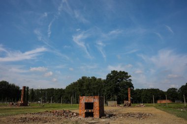 Auschwitz, Oswiecim, Polonya - 02 Ağustos 2019: Auschwitz Birkenau Brzezinka 'daki eski bir Nazi imha kampı. Brzezinka 'daki kışlalar dikenli tellerle harabe ve direklere bırakılmış.