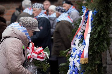Auschwitz-Birkenau, Polonya - 27 Ocak 2018: Auschwitz 'in kurtuluşunun yıldönümü. Toplama kampından sağ kurtulanlar Auschitz-Birkenau Ölüm Duvarı 'nın yanında çiçek katladılar.