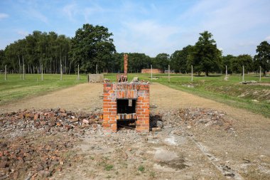 Auschwitz, Oswiecim, Polonya - 02 Ağustos 2019: Auschwitz Birkenau Brzezinka 'daki eski bir Nazi imha kampı. Brzezinka 'daki kışlalar dikenli tellerle harabe ve direklere bırakılmış.