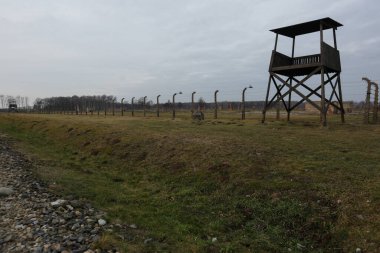 Auschwitz, Oswiecim, Polonya - 27 Ocak 2020: Auschwitz Toplama Kampı Yahudi Soykırımı Müzesi 'nin bir bölümü, dikenli telli elektrikli çit ve izleme kulesi, Arbeit Macht Frei