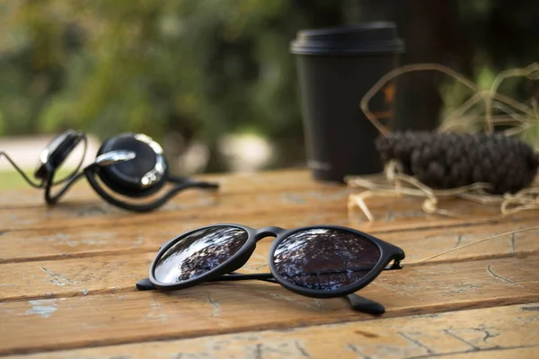 Güneş gözlüğü gözlükleri, doğal park alanında, ahşap masada.