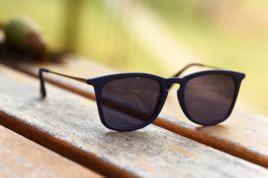 Güneş gözlüğü gözlükleri, doğal park alanında, ahşap masada.