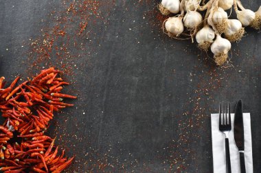 Gri taş arka planda yemek için sarımsak ve kuru biber.