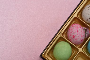 Pembe kağıt arka planda kutuda desenli çikolata topu