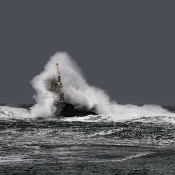 Grande onda contra o velho farol no porto de Ahtopol, Mar Negro, Bulgária em um dia tempestuoso temperamental. Perigo, cena dramática. — Fotografia de Stock