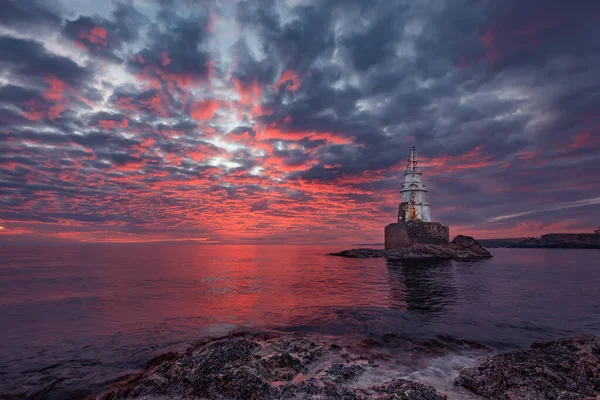日出时的海景美丽的天然海景 黑海海岸的日出 保加利亚 阿赫托波尔 明亮的日出 有云彩和烈日在灯塔前 — 图库照片
