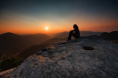 Bulgaristan 'ın Belintash Sığınağı' nda gün batımını izleyen bir kız. Yaz gün batımı görünümü.