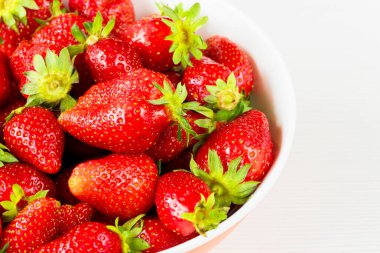 Beyaz arka planda izole edilmiş bir kasedeki kırmızı taze çilekler. Görüntüyü kapat.