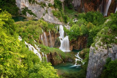 Su üzerinde turkuaz su ve ahşap patikalı güzel şelale manzarası. Plitvice Lakes Ulusal Parkı, Hırvatistan. Ünlü cazibe, yaz manzarası..