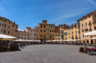 LUCCA, ITALY - 24 Mayıs 2017: kimliği belirsiz insanlarla Piazza del Anfiteatro. Meydanı çevreleyen binalar, Lucca 'nın eski 2. yüzyıl Roma amfitiyatrosunun şeklini takip ediyor.