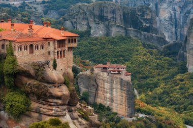 Güzel manzara, Rousanou Kutsal Ortodoks Manastırı (St. Barbara) ve Varlaam, Meteora, Pindos Dağları, Selanik, Yunanistan, Avrupa 'daki taş duvarın arka planında parlak yeşil yapraklar