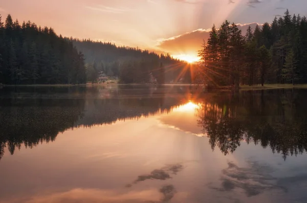 Gün batımının güzel manzarası, dağ gölü üzerinde güneş ışınları. Bulgaristan 'ın Rodopi Dağları' ndaki Shiroka Polyana barajı.