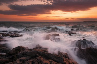 Güneş doğarken deniz manzarası. Güzel doğal deniz manzarası. Karadeniz kıyısında deniz doğuyor. Eylül 'ün başında bulutlar ve ateş güneşiyle muhteşem bir gün doğumu. Chernomorec, Bulgaristan