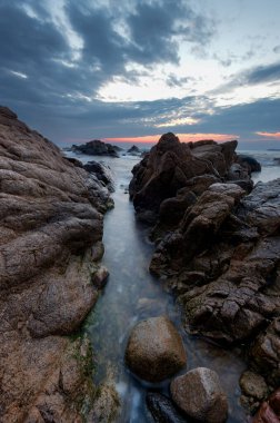 Denizin üzerinde güzel bir gün doğumu. Bulutlu, dramatik gökyüzü, büyük dalgalar. Sahildeki muhteşem bulutlar.
