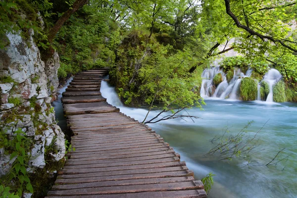 Su üzerinde turkuaz su ve ahşap patikalı güzel şelale manzarası. Plitvice Lakes Ulusal Parkı, Hırvatistan. Ünlü cazibe, yaz manzarası..