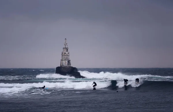巨浪冲向灯塔 保加利亚阿赫托波尔黑暗而狂暴的天气和一个冲浪运动员 戏剧性的场面 — 图库照片
