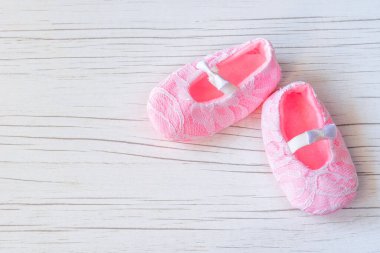 Beyaz ahşap arka planda küçük pembe ayakkabılar. Bekliyorum bebek partisi. Yeni doğmuş pembe kız ayakkabıları. Bebek konsepti için moda ve kıyafetler..