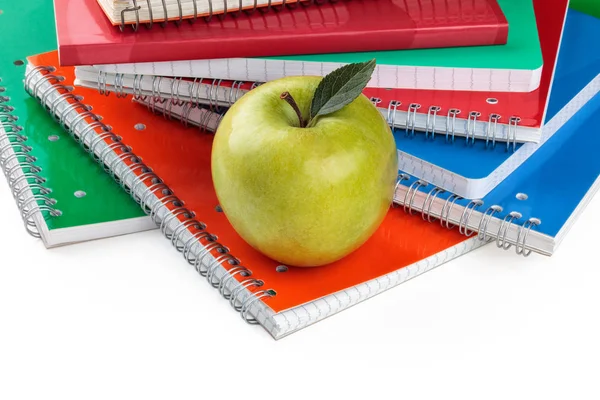 Notizbücher und grüner Apfel. — Stockfoto