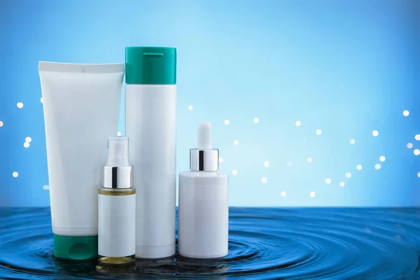 Cosmetic products standing in water with ripples.