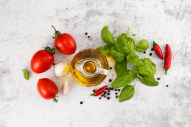 Beyaz masada taze domates, fesleğen ve zeytinyağı. Kopyalama çubuğu ile üst görünüm