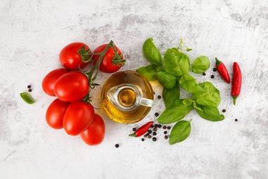 Beyaz masada taze domates, fesleğen ve zeytinyağı. Kopyalama çubuğu ile üst görünüm