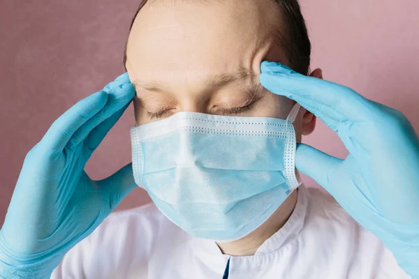 Thinking doctor. Sad and nervous doctor. Closeup portrait of a doctor in blue surgical mask and gloves with closed eyes. Pandemic coronavirus 2020. Quarantine. Virus concept. Epidemic infection.