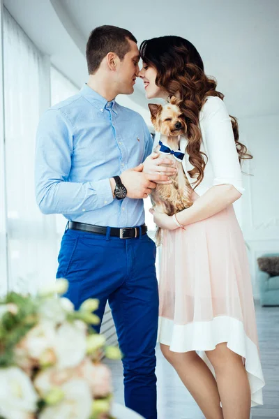 爱情故事 快乐的丈夫和她的妻子站在那里 面带微笑 带着一只狗互相望着 舒适的家漂亮的房间真爱生活方式 刚刚结婚 — 图库照片