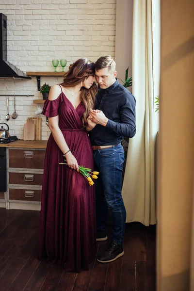一对可爱的夫妇站在厨房里 一个手里拿着黄色郁金香的女人她的手在他手里和谐的家庭浪漫的爱情故事幸福 — 图库照片