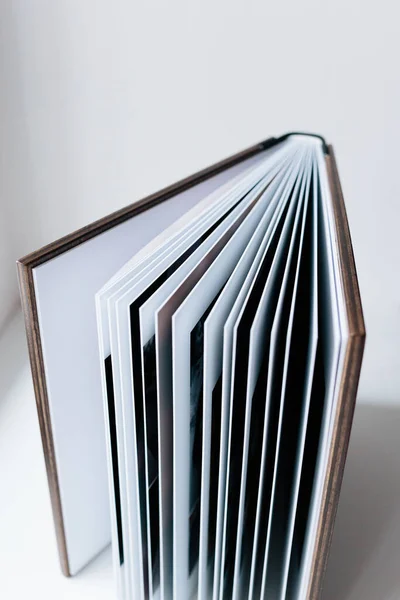 An open photo book with a wooden cover stands on the white background. Flat lay. — Stock Photo, Image