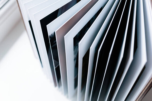 An open photo book with a wooden cover stands on the white background. Flat lay.