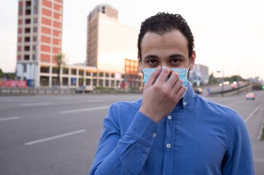 Şehrin koruyucu maskesi takmış Orta Doğu 'lu genç bir adamın portresi. Sosyal mesafe. 2020 pandemik koronavirüs. Karantinaya alın. Virüs konsepti. metin için yer