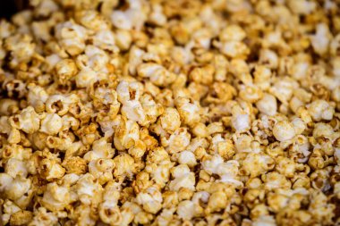 Büyük bir grup şeker kaplı taze patlamış mısır bir sokak gıda pazarında satışa sunuldu. Yumuşak sarı ışıkta yumuşak bir odak ile fotoğraflandı. Sağlıklı yiyeceklerin üst görüntüsü yumuşak odaklı fotoğraflandı.