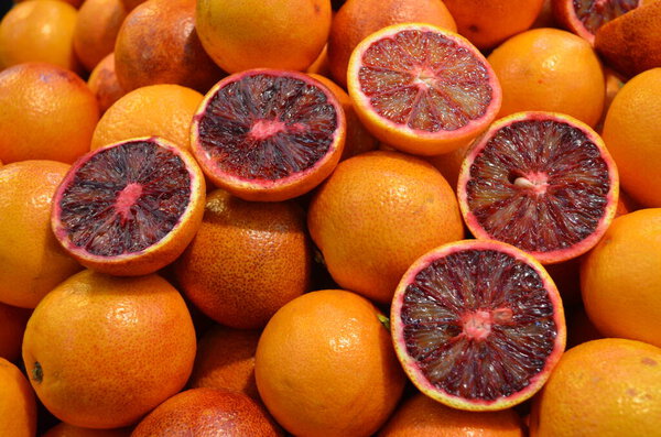 Many fresh ripe organic Spanish oranges displayed for sale in Central Market Hall in Budapest, Hungary, side  view of flat flay of healthy food photographed with soft focus in yellow light