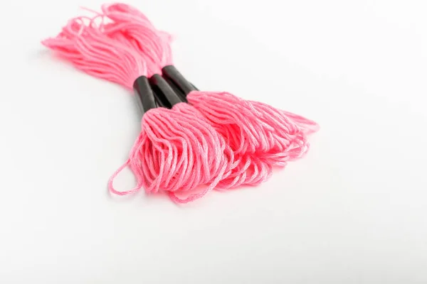 三根鲜明的粉红色绣花缝纫线 隔离在白桌 顶视图或平铺的纺织材料上 — 图库照片