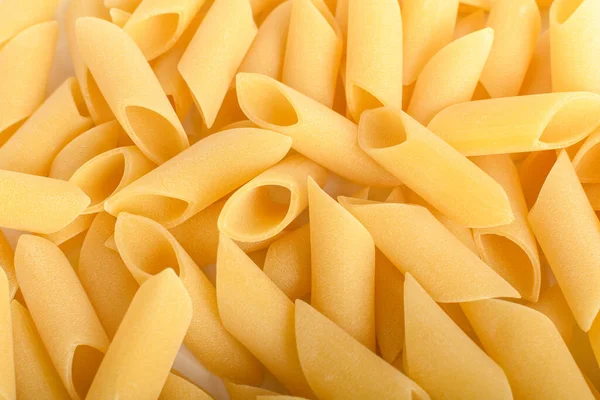 乾燥したメッツェ ペンネのヒープ調理される準備ができてイタリアのパスタは 健康的な食品の白いテーブル トップビューまたはフラットレイアウトに隔離されました — ストック写真