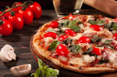 Tahtada pastırmalı ve mantarlı pizza. Domates ve fesleğen.